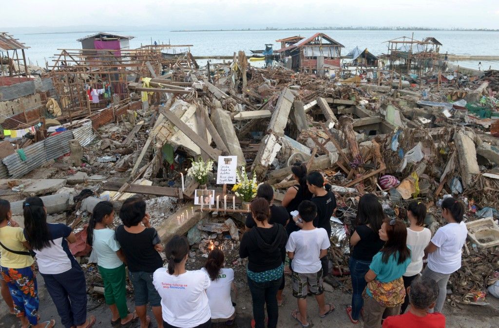 people mourn the victims of Typhoon Haiyan/ AFP