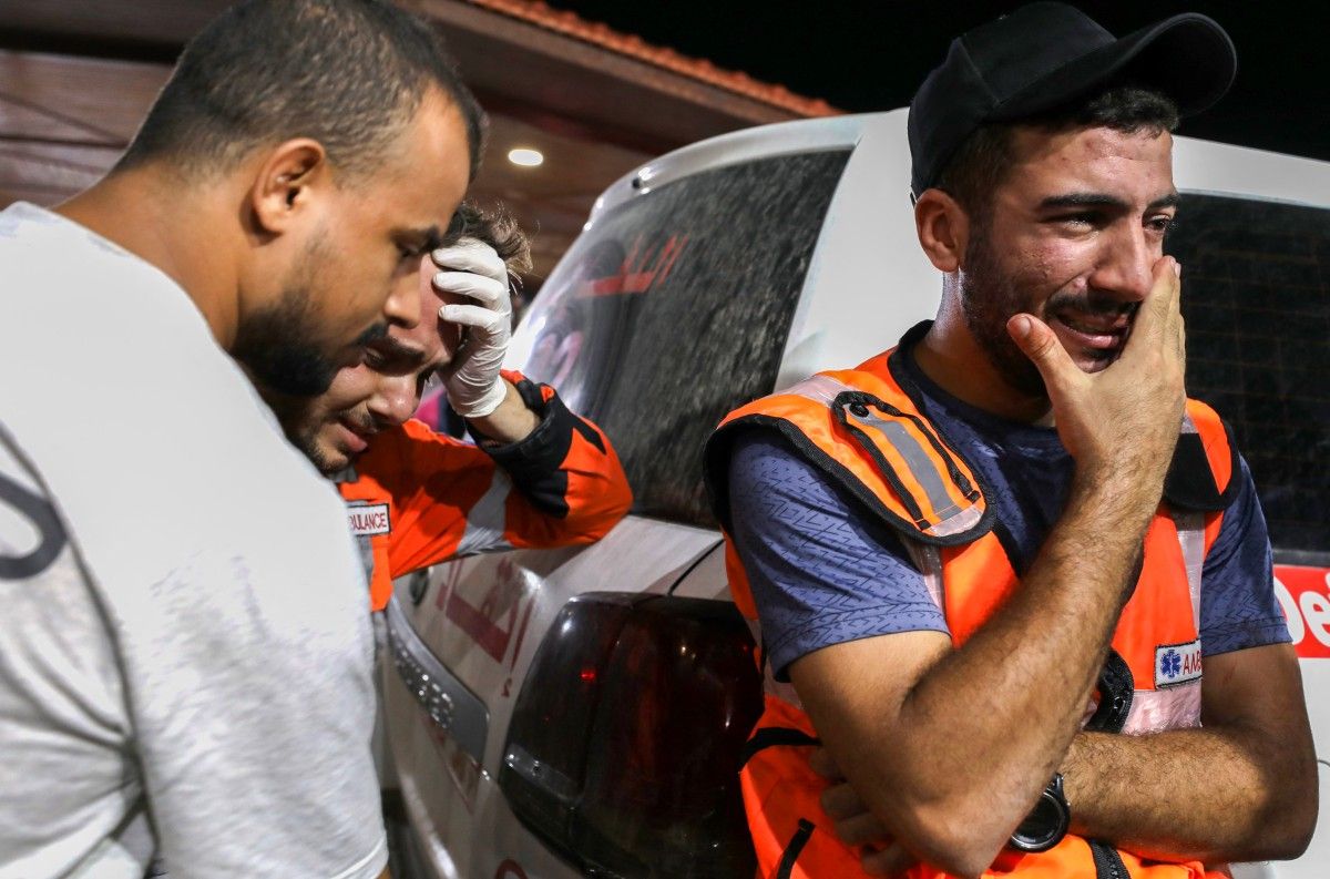 Palestinian paramedics cry after bombardment/ AFP  