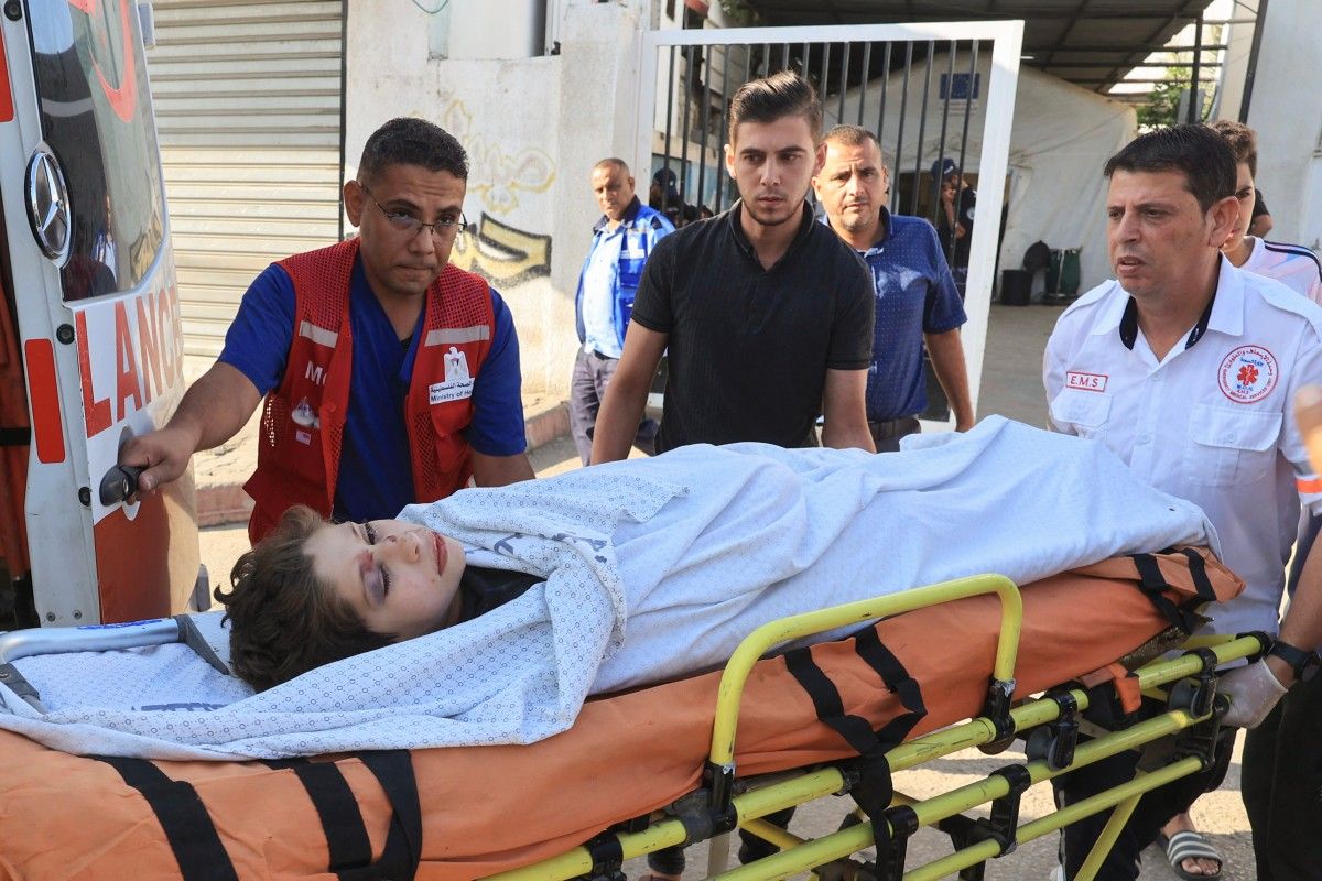 Medics transport a youth injured in Israeli airstrikes on Beit al-Jazzar area, into al-Najjar hospital in Rafah city/ AFP